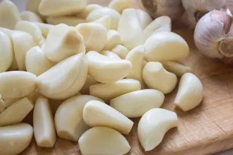 Stos czosnku, naturalny sposób na ziemiórki. Ząbki czosnku gotowe do użycia w ogrodzie.